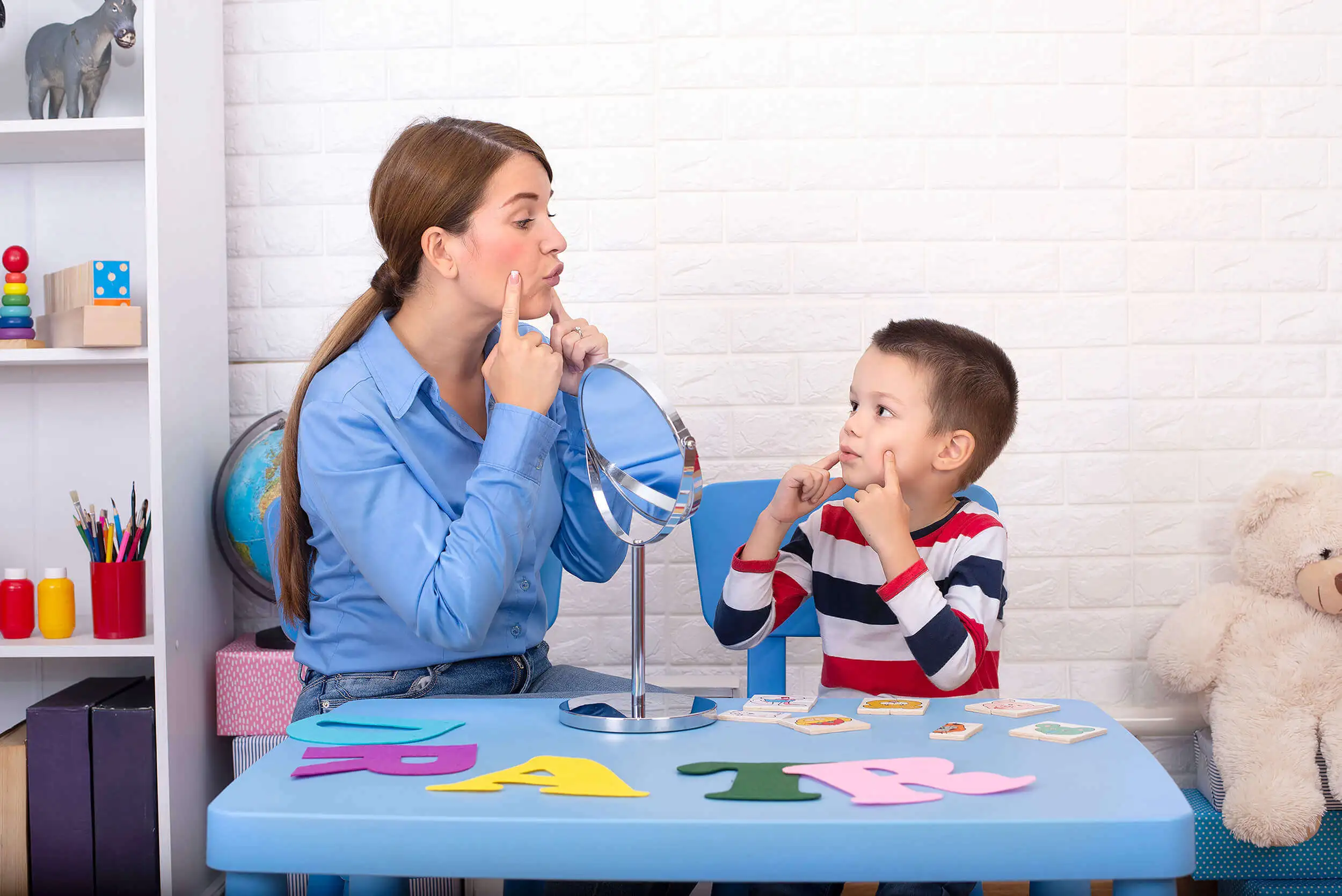 A woman sitting at a table working with a child